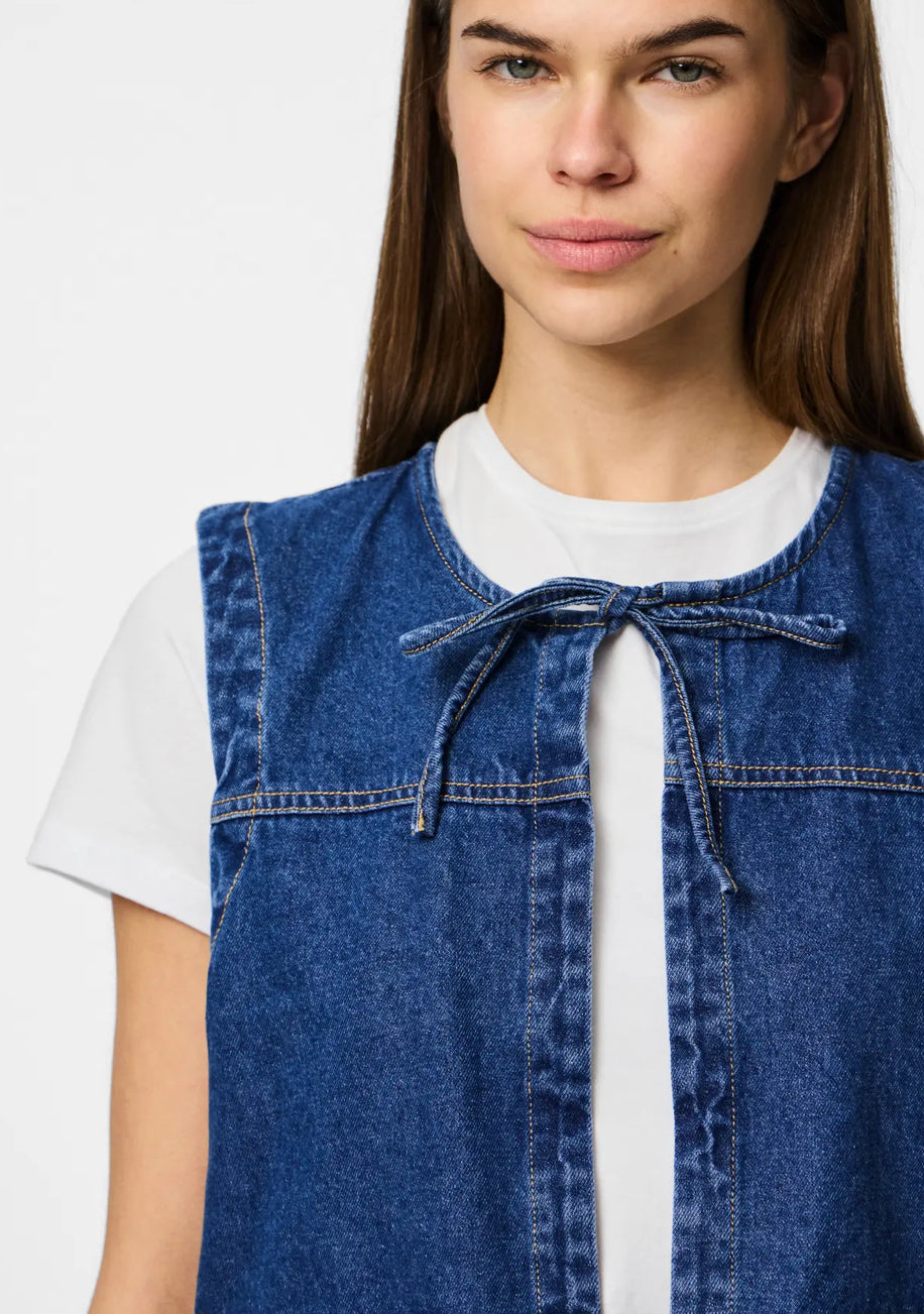 Nærbillede af denim vest fra pieces, smart og trendy, her på billedet er den vist på model med hvid tee under